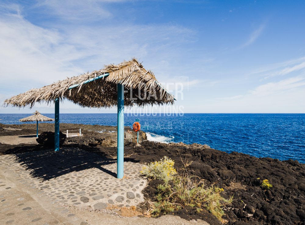 La Palma. El Charco Azul. Clear blue ocean and people sunbathing and swimming.